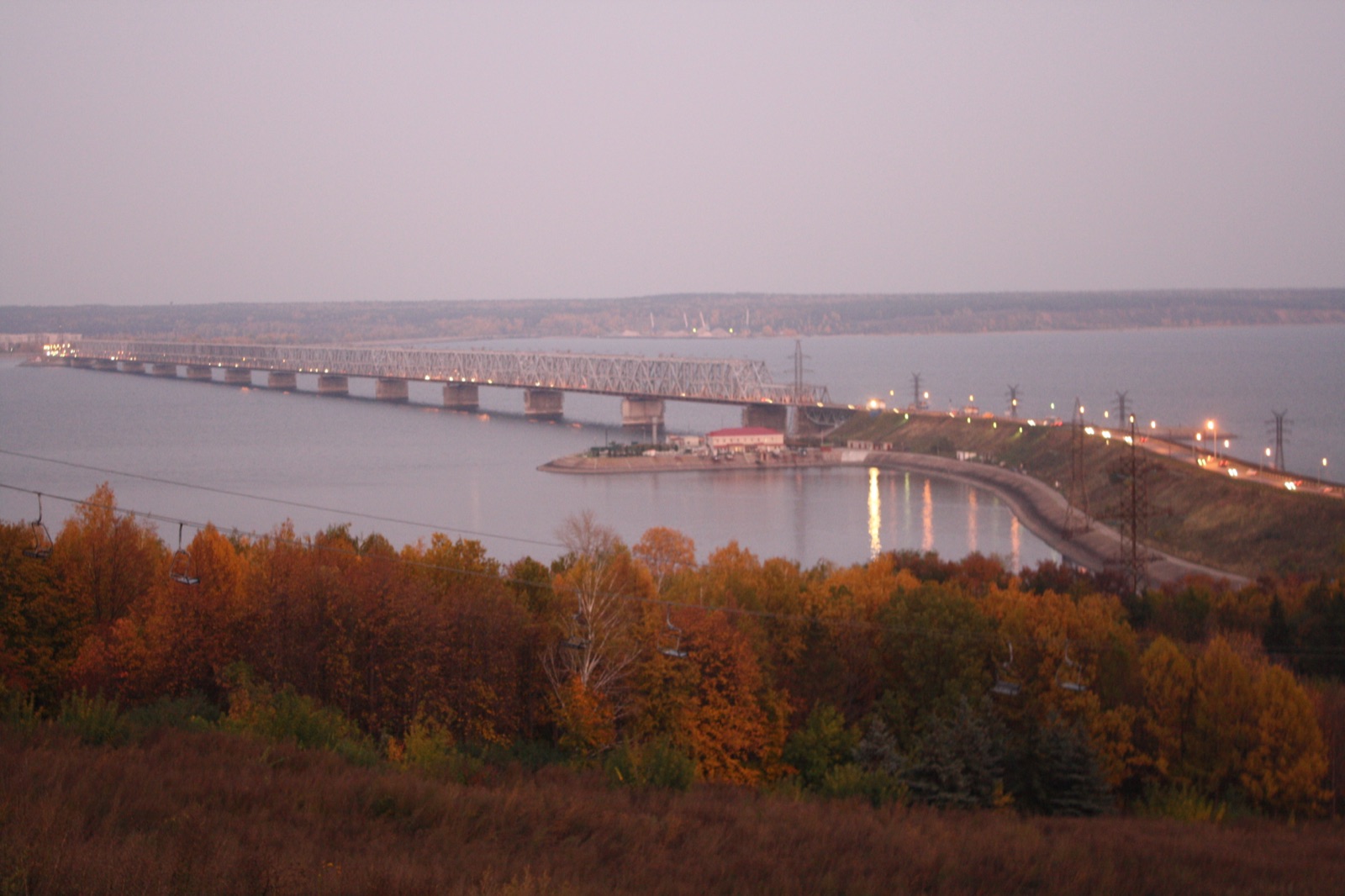Ульяновск: мост через Волгу (Куйбышевское водохранилище) с вечерней подсветкой, вид с высокого берега, на склоне осенние деревья